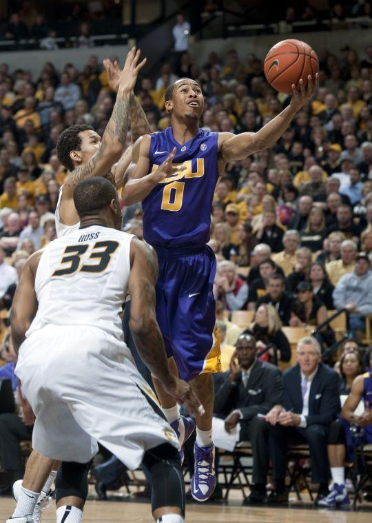 LSU's Charles Carmouche, right, shoots past Negus Webster-Chan, left, and Earnest Ross (33) during the second half of an NCAA college basketball game Saturday, March 2, 2013, in Columbia, Mo. Missouri won the game 89-76. (AP Photo/L.G. Patterson)
 