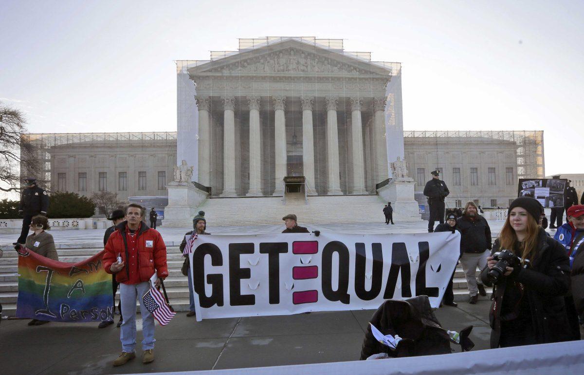 Demonstrators stand outside the Supreme Court in Washington, Tuesday, March 26, 2013, where the court will hear arguments on California&#8217;s voter approved ban on same-sex marriage, Proposition 8. (AP Photo/Pablo Martinez Monsivais)