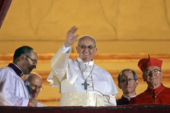 Pope Francis waves to the crowd from the central balcony of St. Peter's Basilica at the Vatican, Wednesday, March 13, 2013. Cardinal Jorge Bergoglio, who chose the name of Francis is the 266th pontiff of the Roman Catholic Church. (AP Photo/Gregorio Borgia)
 