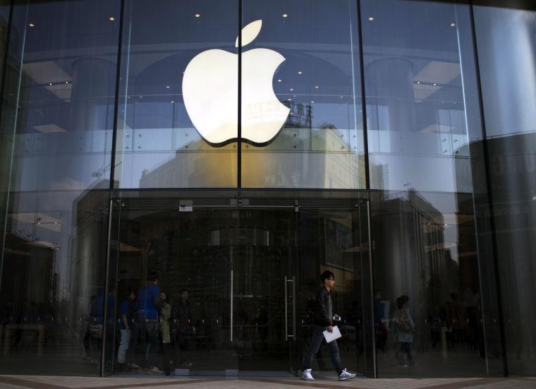 In this Monday April 1, 2013 photo, a man leaves an Apple store with an iPhone and an iPad in his hands in central Beijing, China. Apple Inc., the maker of the iPhone and iPad, reports quarterly financial results after the market closes on Tuesday. April 23, 2013. (AP Photo/Alexander F. Yuan)
 