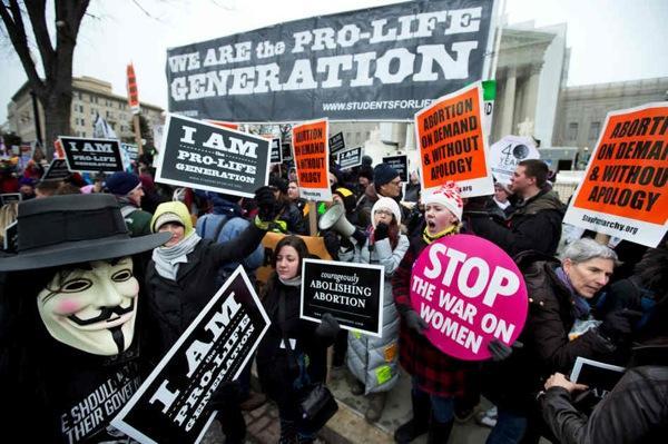 Pro-abortion rights activists, rally face-to-face against anti-abortion demonstrators as both march in front of the U.S. Supreme Court in Washington, Friday, Jan. 25, 2013, in a demonstration that coincides with the 40th anniversary of the Roe vs. Wade decision that legalized abortion. (AP Photo/Manuel Balce Ceneta)
 