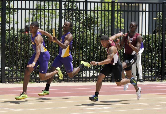 LSU sophomore sprinter Aaron Ernest (left) passes the baton to fresman sprinter Nethaneel Mitchell-Blake (far left) April 20, 2013 during the LSU Alumni Gold meet in Bernie Moore Track Stadium.
 