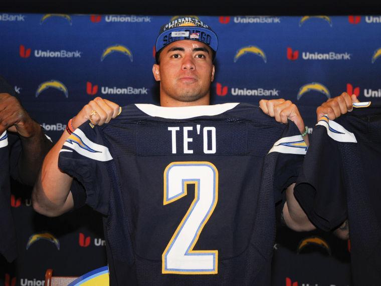 San Diego Chargers draft pick, inside linebacker Manti Te'o, from Notre Dame, holds up his Chargers jersey during an NFL football news conference at the Chargers' facility Saturday, April 27, 2013 in San Diego. (AP Photo/Denis Poroy)
 