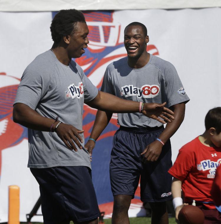 NFL draft prospects Barkevious Mingo of LSU, right, and Ezekiel Ansah of Brigham Young participate in a youth football clinic in New York, Wednesday, April 24, 2013. The draft starts Thursday. (AP Photo/Seth Wenig)
 