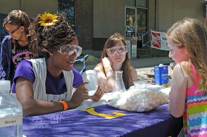 Biochemistry junior Dant&#233; Johnson (left) and environmental management and chemistry sophomore Autumn Aceree (middle), talk to first grader Kenlie Jackson about packing material on Sunday, April 21, 2013, for Louisiana Earth Day held in downtown Baton Rouge.
 