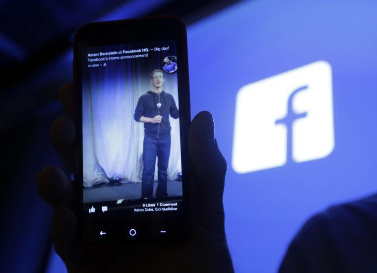 Michael Goodwin, Senior Partner for HTC, displays an HTC First cell phone wit the new Facebook interface at Facebook headquarters in Menlo Park, Calif., Thursday, April 4, 2013. The company says it is not building a phone or an operating system. Rather, Facebook is introducing a new experience for Android phones. The idea behind the new Home service is to bring content right to you, rather than require people to check apps on the device. (AP Photo/Marcio Jose Sanchez)
 