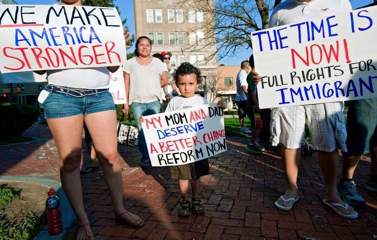 Anthony Alexandra Ayala, 3, stands with his mom, Anyi Barahona, left, who immigrated from Honduras nine years ago, and dad, Hector Rosales, right, who immigrated from Guatemala 13 years ago, during an immigration reform rally at the Court Square in Harrisonburg, Va., on Wednesday, April 10, 2013. Tens of thousands of immigrants and activists rallied nationwide Wednesday in a coordinated set of protests aimed at pressing Congress to approve immigration measures that would grant 11 million immigrants living here illegally a path toward citizenship. (AP Photo/The Daily News-Record, Jason Lenhart)