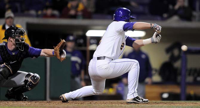 LSU sophomore catcher Tyler Moore (2) bunts the ball Friday, March 8, 2013 during the Tigers' 9-4 victory against the Washington Huskies in Alex Box Stadium.