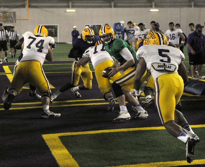 Junior wide receiver Jarrett Fobbs (5) sprints forward as Senior quarterback Zach Mettenberger (8) prepares to pass the ball to him during the "big cat" drill Tuesday, April 16, 2013.
 