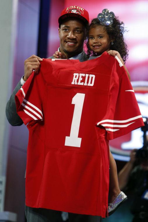 Eric Reid, from Louisiana State, holds up a team jersey and his daughter after being selected 18th overall by the San Francisco 49ers in the first round of the NFL football draft, Thursday, April 25, 2013, at Radio City Music Hall in New York. (AP Photo/Jason DeCrow)
 