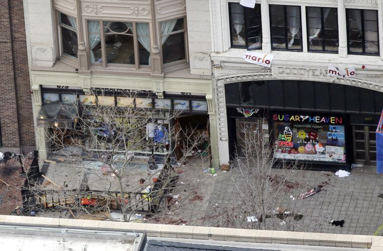 Debris is spread along the sidewalk of one of the blast sites on Boylston Street near the finish line of the 2013 Boston Marathon in the wake of two blasts in Boston Monday, April 15, 2013. (AP Photo/Elise Amendola)
 