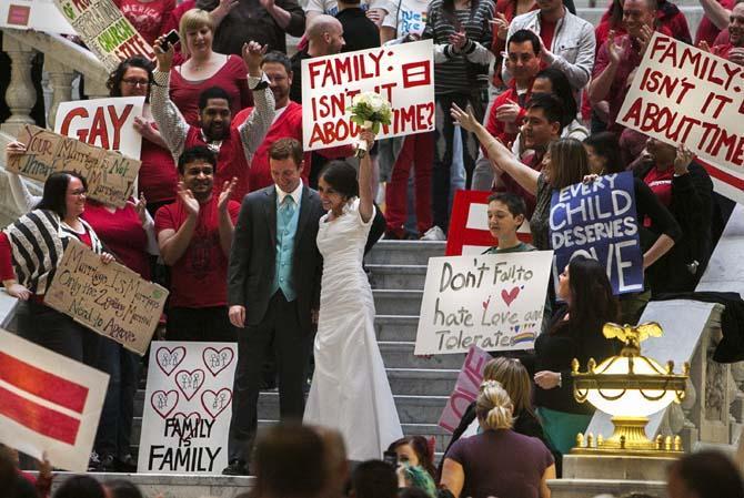 Jordan and Amanda, (no last names given) have a photo taken on the steps amid same sex marriage supporters during a traditional marriage celebration Tuesday, March 26, 2013 at the Utah State Capitol. The U.S. Supreme Court heard arguments on the constitutionality of Calif., Proposition 8 and the Defense of Marriage Act on Tuesday, March 26, 2013. (AP Photo/Deseret News, Scott G Winterton)
 