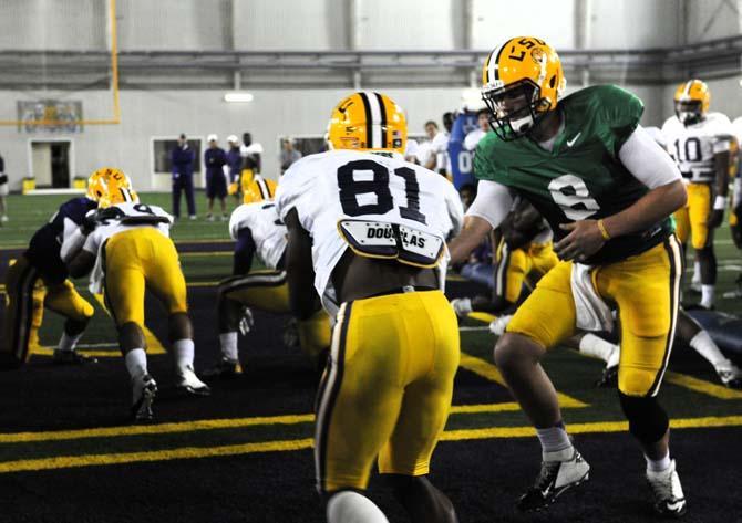 Senior quarterback Zach Mettenberger (8) passes the football to Junior wide receiver Armand Williams (81) as they run a "big cat" drill Tuesday, April 16, 2013.