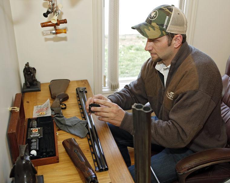 In this photo taken on Friday, April 12, 2013, Gaspar Perricone cleans one of his guns at his home in Denver. Perricone co-founded The Bull Moose Sportsmen&#8217;s Alliance, a group that took the unusual step earlier this month of releasing a poll that showed wide support among hunters for universal background checks. Most public polls have shown about 90 percent of voters support such a measure. (AP Photo/Ed Andrieski)
 