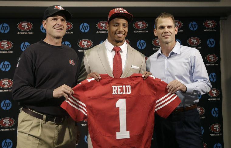 Safety Eric Reid, the first-round draft pick of the San Francisco 49ers, center, holds up a jersey with head coach Jim Harbaugh, left, and general manager Trent Baalke during a news conference at the team's training facility in Santa Clara, Calif., Friday, April 26, 2013. (AP Photo/Jeff Chiu)
 