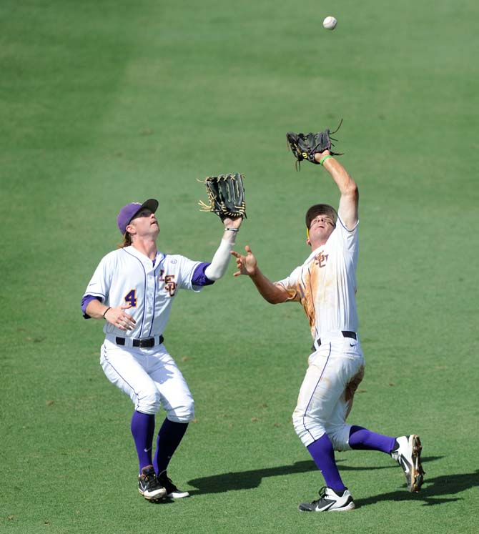 LSU senior outfielder Raph Rhymes (4) and freshman infielder Alex Bregman (30) try for a fly ball shortly before they collided on May 31, 2013. Both players fell to the ground with injuries and were removed from the game.
 