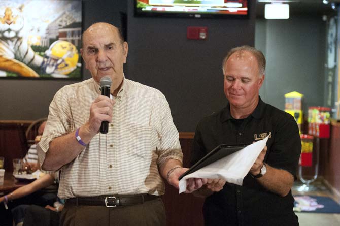 Former LSU athletic director and baseball coach Skip Bertman (left) talks to a crowd while current head baseball coach Paul Mainieri (right) holds a plaque May 27, 2013 at Walk On's Bistreaux and Bar.
 