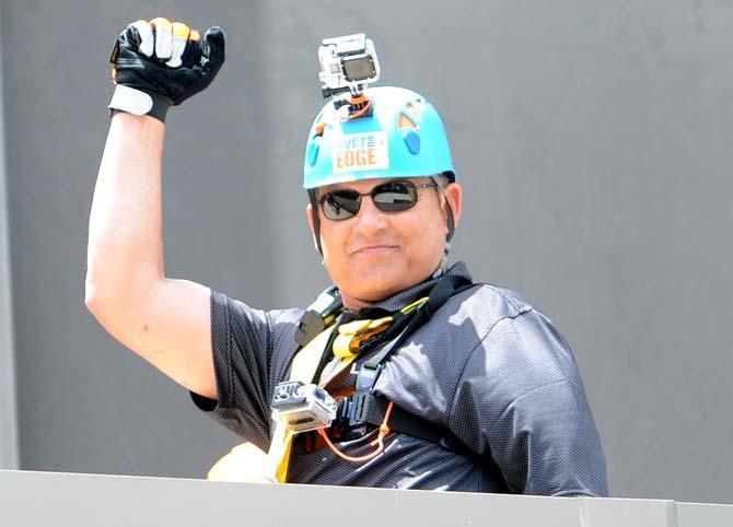 LSU coach Les Miles raises a fist in triumph at the base of the Capitol One building Thursday, May 30, 2013 after his rappel down the 24 story structure in downtown Baton Rouge. Miles' descent is in effort to raise awareness for Louisiana children available for adoption.
 