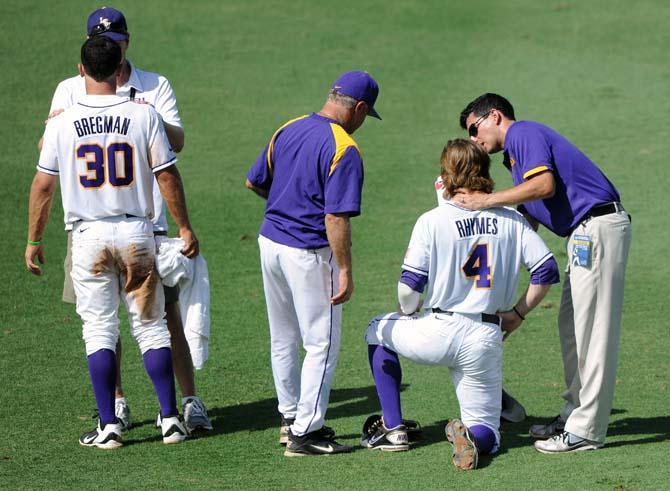 LSU baseball coaches and staff examine freshman infielder Alex Bregman (30) and senior outfielder Raph Rhymes (4) after the two collided early in the Tigers' 11-7 win against Jackson State in Alex Box Stadium.
 