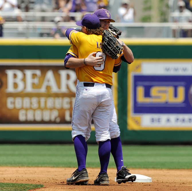 LSU seniors Raph Rhymes (4) and Mason Katz (8) embrace May 18, 2013 as they are called off the field early in the last game of the regular season. The Tigers lost to Ole Miss 9-11.
 