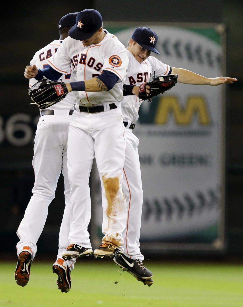 Houston Astros' Chris Carter, left, Brandon Barnes, center, and Ronnie Grossman celebrate their 10-3 win over the Seattle Mariners inning of a baseball game, Wednesday, April 24, 2013, in Houston. (AP Photo/Pat Sullivan)