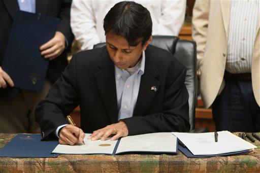 Louisiana Governor Bobby Jindal signs one of six gun-related bills at TP Outdoors in West Monroe, La, on Wednesday, June 19, 2013. Despite criticism it would violate the First Amendment, Gov. Bobby Jindal on Wednesday signed into law a bill that makes it a crime for journalists or anyone else to publicly identify concealed handgun permit holders or applicants (AP Photo/The News-Star, Emerald McIntyre) NO SALES
 