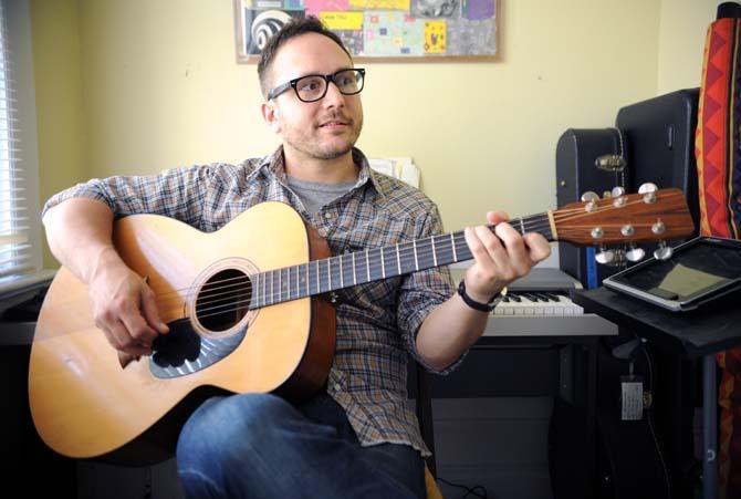 Matthew Schwartz, vocalist, guitarist and percussionist for local rock band Pacifico, strums his guitar Tuesday, June 11, 2013 in his apartment.
 