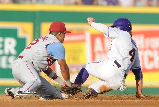 Oklahoma junior infielder Hector Lorenzana (12) tries to tag out LSU senior outfielder Raph Rhymes (4) on June 7, 2013 during the Tigers' 2-0 win against the Sooners in Alex Box Stadium.
 