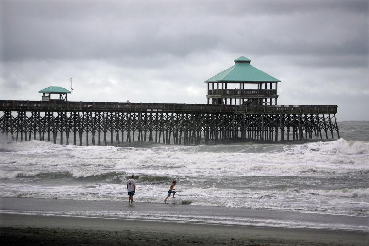 Beachgoers play in waves at Folly Beach from Tropical Storm Andrea, Friday, June 7, 2013 in Charleston, S.C. Tropical Storm Andrea moved quickly across south Georgia and was leaving the Carolinas waterlogged on Friday while sparing the area any serious damage. (AP Photo/The Post And Courier, Leroy Burnell)
 