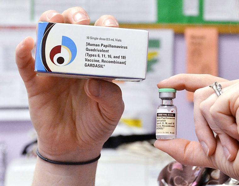 FILE - A child health nurse holds up a vial and box for the HPV vaccine, brand name Gardasil, at a clinic in Kinston, N.C. on Monday March 5, 2012. A vaccine against a cervical cancer virus has cut infections in teen girls by half, according to a study released Wednesday, June 19, 2013. The study confirms research done before the HPV vaccine came on the market in 2006. But this is the first evidence of how well it works now that it is in general use. (AP Photo/Daily Free Press, Charles Buchanan)
 