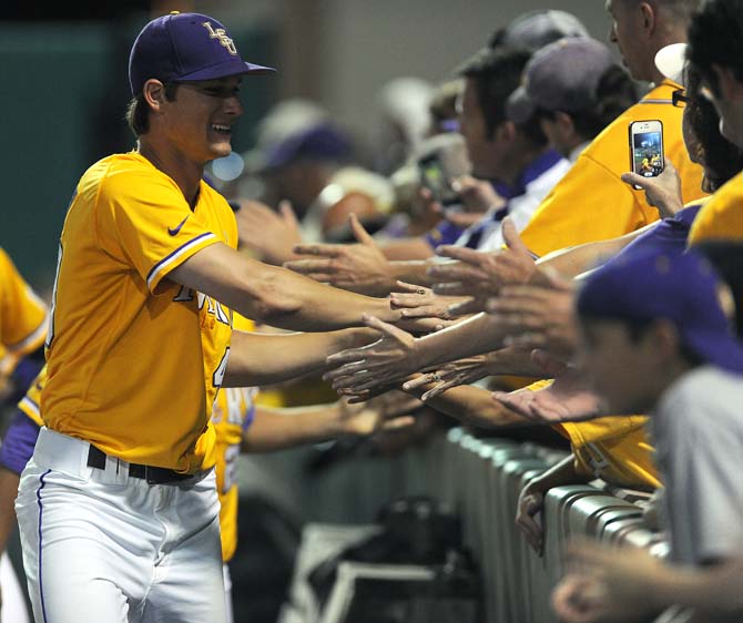 LSU senior pitcher Brent Bonvillain (49) high-fives fans following the Tigers' 5-1 win against ULL in the Baton Rouge Regional championship in Alex Box Stadium.
 