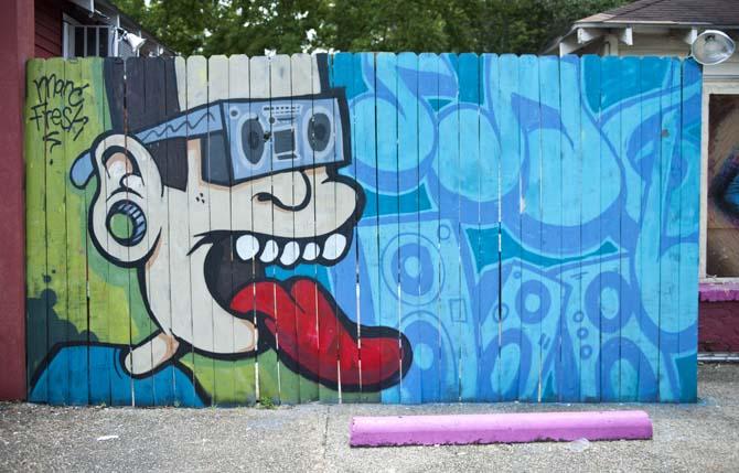 A large painting by Marc Verret, also known as Marc Fresh, is displayed on a fence Monday, June 10, 2013 on Government Street.
 