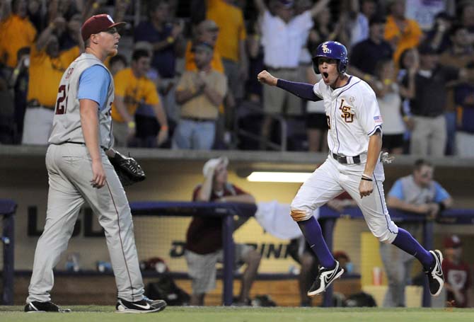 LSU junior infielder JaCoby Jones (23) taunts Oklahoma pitcher Jonathan Gray (22) as he scores the go-ahead run in the first game of the Baton Rouge Super Regional on June 7, 2013. Gray allowed five hits in the game. The Tigers won 2-0.
 