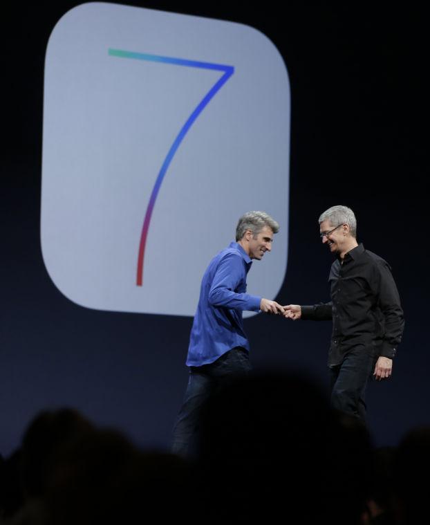 Craig Federighi, senior vice president of software engineering at Apple, left, greets Apple CEO Tim Cook after the introduction of iOS 7 during the keynote address of the Apple Worldwide Developers Conference, Monday, June 10, 2013, in San Francisco. (AP Photo/Eric Risberg)
 