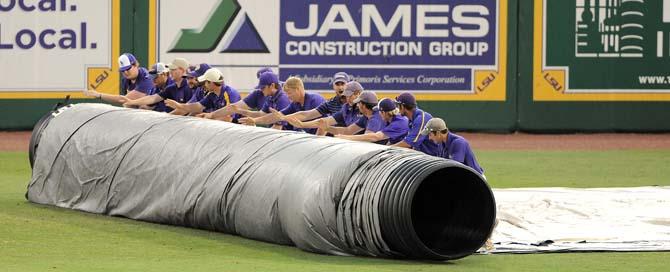 Alex Box Stadium's grounds crew rolls out the tarp June 8, 2013 during a rain delay in LSU's game against Oklahoma.
 