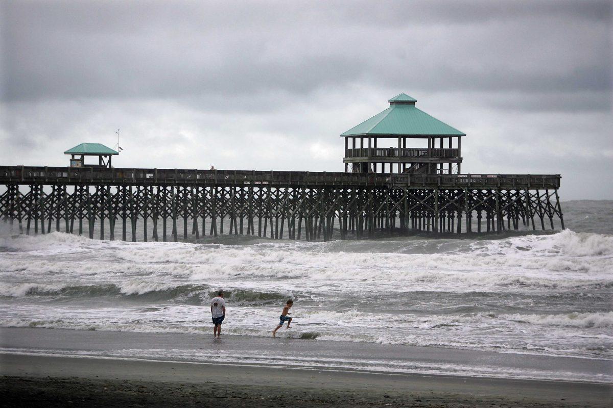 Beachgoers play in waves at Folly Beach from Tropical Storm Andrea, Friday, June 7, 2013 in Charleston, S.C. Tropical Storm Andrea moved quickly across south Georgia and was leaving the Carolinas waterlogged on Friday while sparing the area any serious damage. (AP Photo/The Post And Courier, Leroy Burnell)