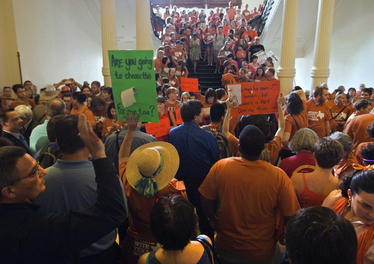 A large crowd, many wearing Planned Parenthood T-shirts that read &#8220;Stand with Texas Woman,&#8221; gather at the Texas State Capitol in Austin, Texas on Sunday, June 23, 2013. More than 600 women's rights protesters crowded into the Texas Capitol to watch Democrats begin a series of parliamentary maneuvers to stop the Republican majority from passing some of the toughest abortion restrictions in the country. (AP Photo/Austin American-Statesman/Statesman.com, Ricardo B. Brazziell)