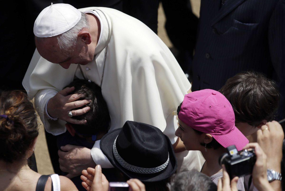 Pope Francis hugs a child after he delivered the Angelus prayer at the Pontiff's residence of Castel Gandolfo, near Rome, Sunday July 14, 2013. For a day, Pope Francis has abandoned his traditional Sunday greeting at the Vatican, opting for an informal front-door encounter in a hill town outside Rome which hosts the papal summer residence. Unlike his predecessors, Francis isn't staying in Castel Gandolfo for the summer, but came for the day. (AP Photo/Gregorio Borgia)