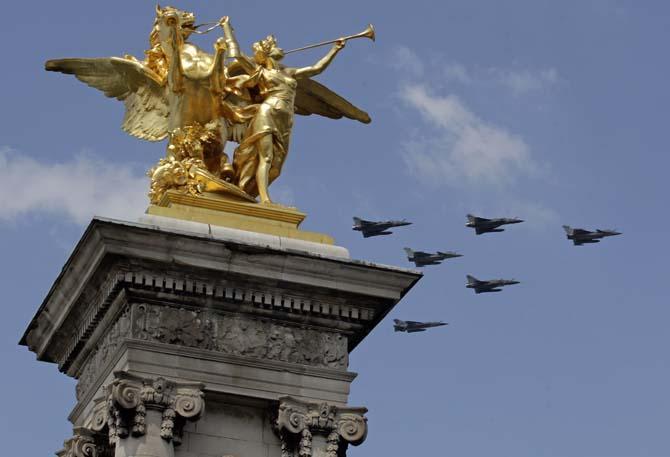 A patrol made of French Air Force Rafales and Mirage 2000 jet fighters, right, flies above the Alexandre III bridge in Paris, Tuesday July 9, 2013, as part of a rehearsal for the July 14th Bastille Day Parade.(AP Photo/Remy de la Mauviniere)