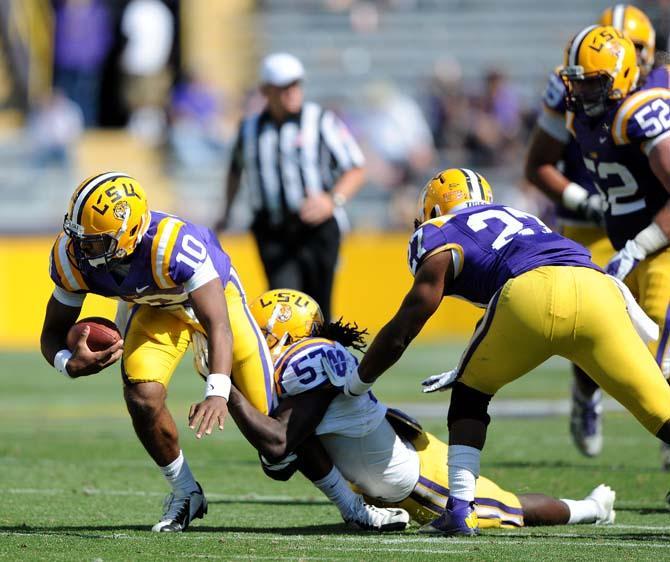 Freshman quarterback Anthony Jennings (10) is tackled by senior linebacker Lamin Barrow (57) April 20, 2013 during the white squad's 37-0 victory against the purple squad in the National L Club Spring Game in Tiger Stadium.