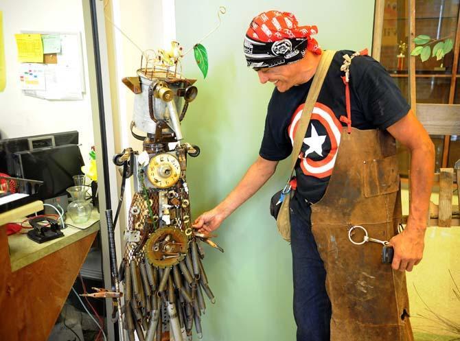 Joseph Jilbert shows off his Robot Dufroque sculpture Wednesday Aug. 21, 2013, which is assembled with items brought in by students to be auctioned off in the upcoming raffle.