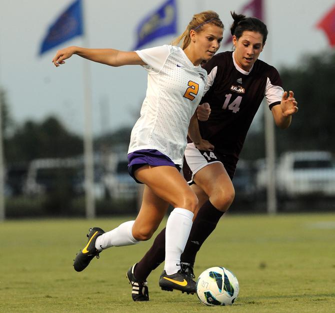 LSU senior defender Addie Eggleston (2) dribbles the ball past University of Louisiana-Monroe freshman midfielder Nancy Kirk (14) on Aug. 27, 2013 during the Tigers' 6-0 victory over the Warhawks at the LSU Soccer Stadium.