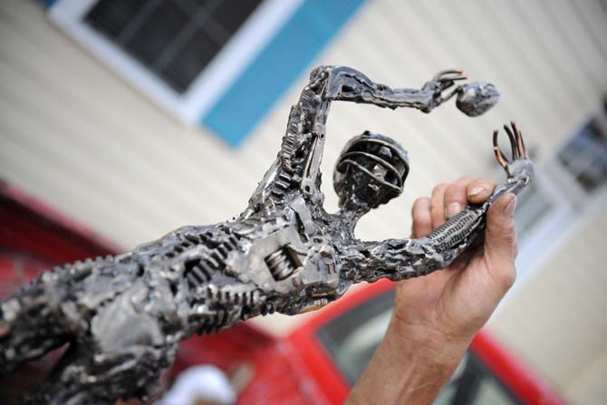 Joseph Jilbert shows off one of his smaller sculptures Wednesday Aug. 21, 2013 in front of his home