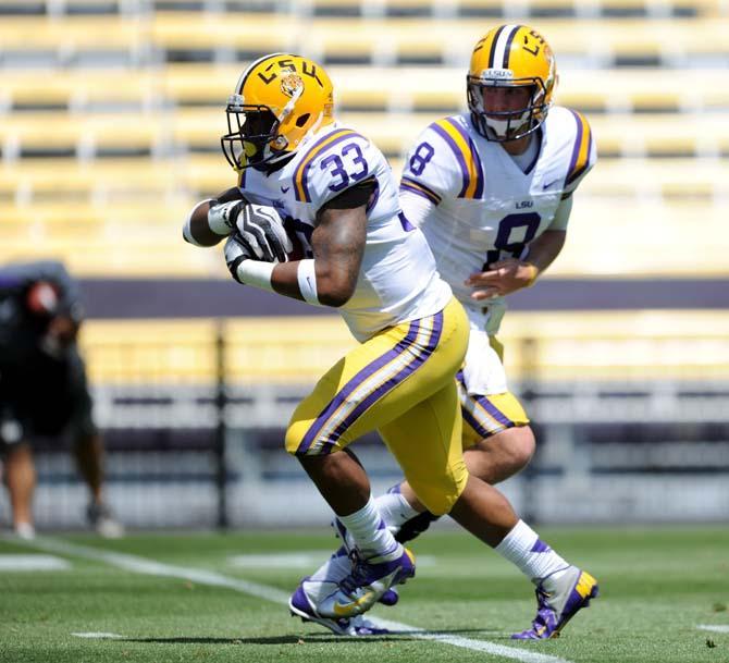 LSU sophomore running back Jeremy Hill (33) takes a hand off from senior quarterback Zach Mettenberger (8) Saturday, April 20, 2013 in the National L Club Spring Game in Tiger Stadium.