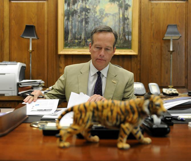 LSU President and Chancellor F. King Alexander looks through papers on his desk Monday, Aug. 19, 2013 in the System Building.