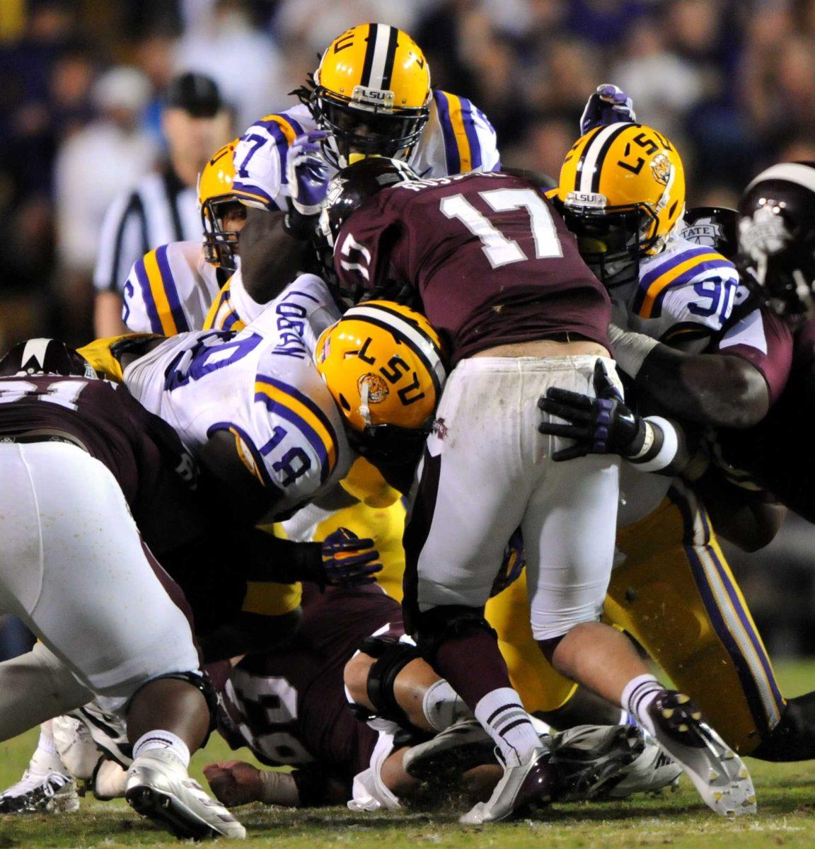 LSU junior defensive tackle Bennie Logan (18), junior linebacker Lamin Barrow (57), and sophomore defensive tackle Anthony Johnson (90) stop MSU junior quarterback Tyler Russell during the Tiger's 37-17 victory over Bulldogs on Saturday, Nov. 10, 2012 in Tiger Stadium.