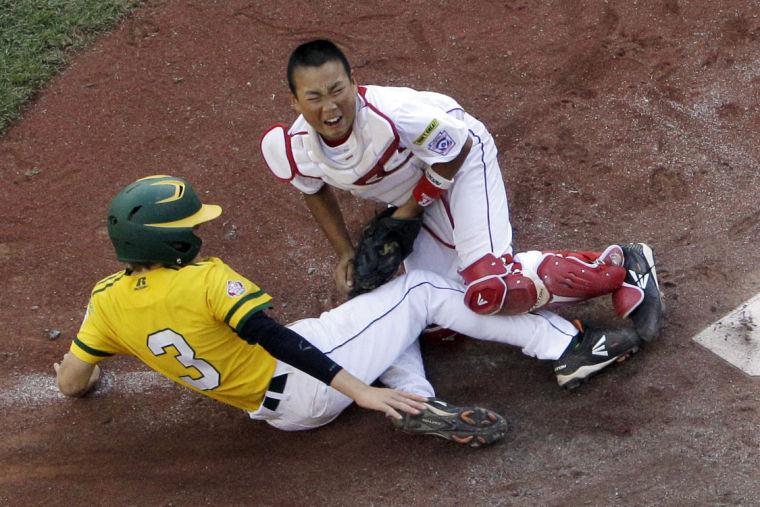 Tokyo, Japan, catcher Ryusei Hirooka, top, blocks the plate and tags out Chula Vista, Calif.'s Patrick Archer (3) who tried to tag up and score on a fly out by Calif.'s Jake Espinoza in the fifth inning of the Little League World Series Championship baseball game in South Williamsport, Pa., Sunday, Aug. 25, 2013.