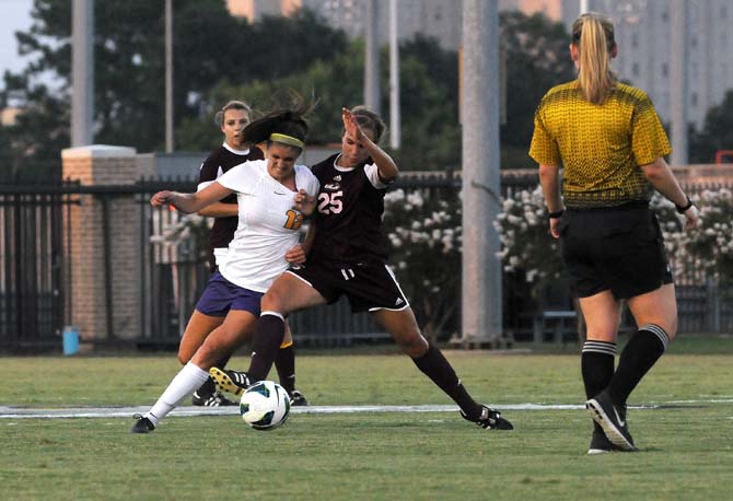 LSU sophomore midfielder Heather Magee (12) fights for possession Tuesday, Aug. 27, 2013 during the Tigers' 6-0 victory against ULM in the LSU Soccer Stadium.