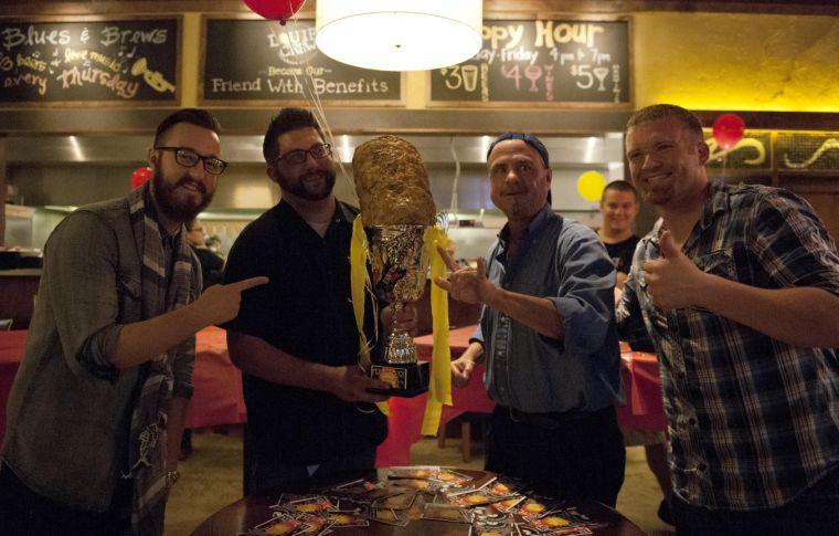 Bob Kuhns claims his tater tot trophy for first place Thursday night, Sept. 19, 2013 at Bar Louie's Rock The Tot eating competition. In 2012, Kuhns won second place in the national Rock The Tot competition.