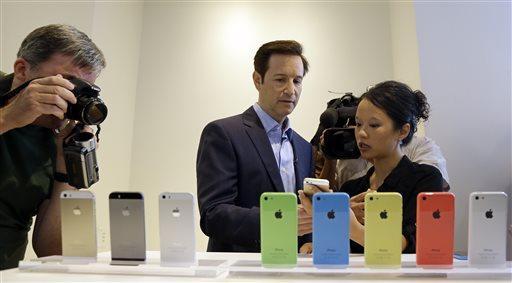 Members of the media review the new iPhone 5c and 5s during a new product announcement at Apple headquarters on Tuesday, Sept. 10, 2013, in Cupertino, Calif. Apple&#8217;s latest iPhones will come in a bevy of colors and two distinct designs, one made of plastic and the other that aims to be &#8220;the gold standard of smartphones&#8221; and reads your fingerprint. (AP Photo/Marcio Jose Sanchez)